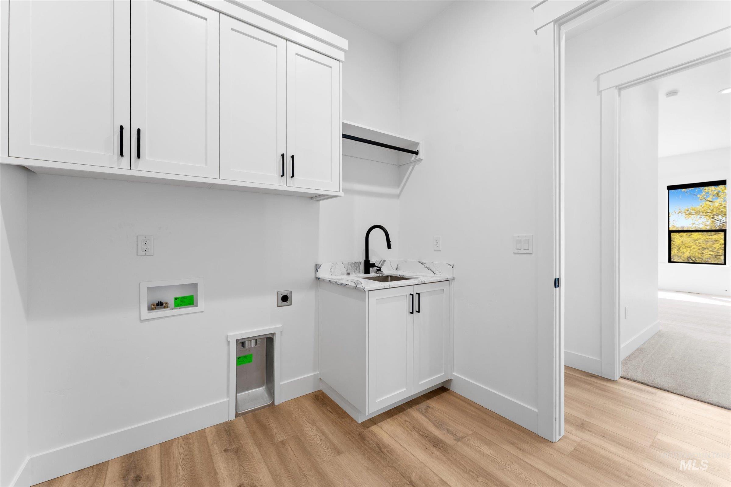 26219 Reed Lane Wilder, ID 83676 - Photo 29 of 35 Laundry room featuring light wood-style flooring, hookup for an electric dryer, cabinet space, and washer hookup