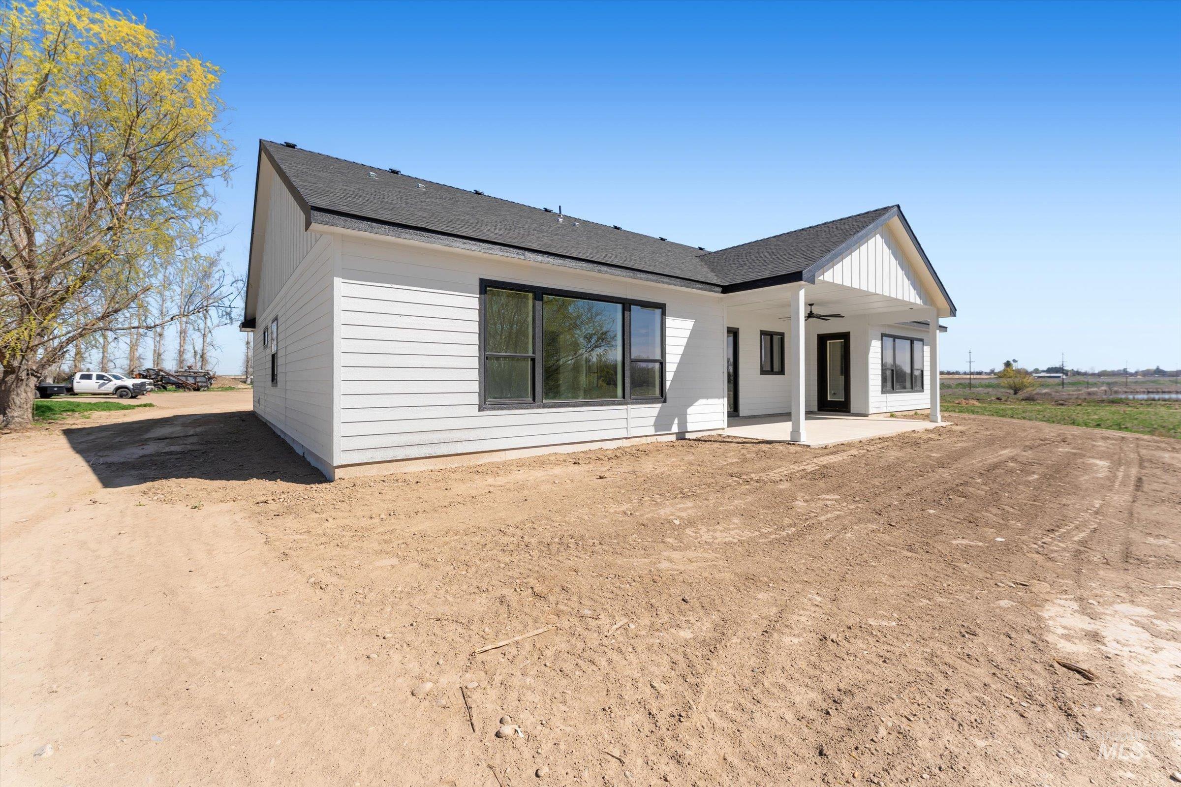 26219 Reed Lane Wilder, ID 83676 - Photo 32 of 35 Rear view of house featuring ceiling fan, a patio, and roof with shingles