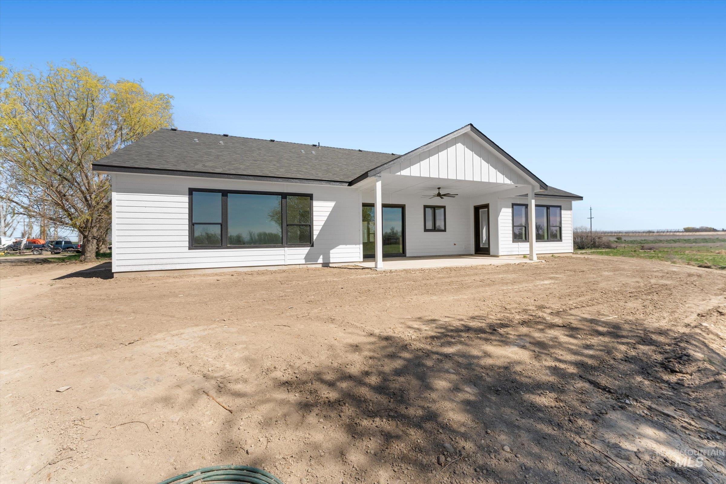26219 Reed Lane Wilder, ID 83676 - Photo 33 of 35 Rear view of property featuring a patio, a shingled roof, a ceiling fan, and board and batten siding