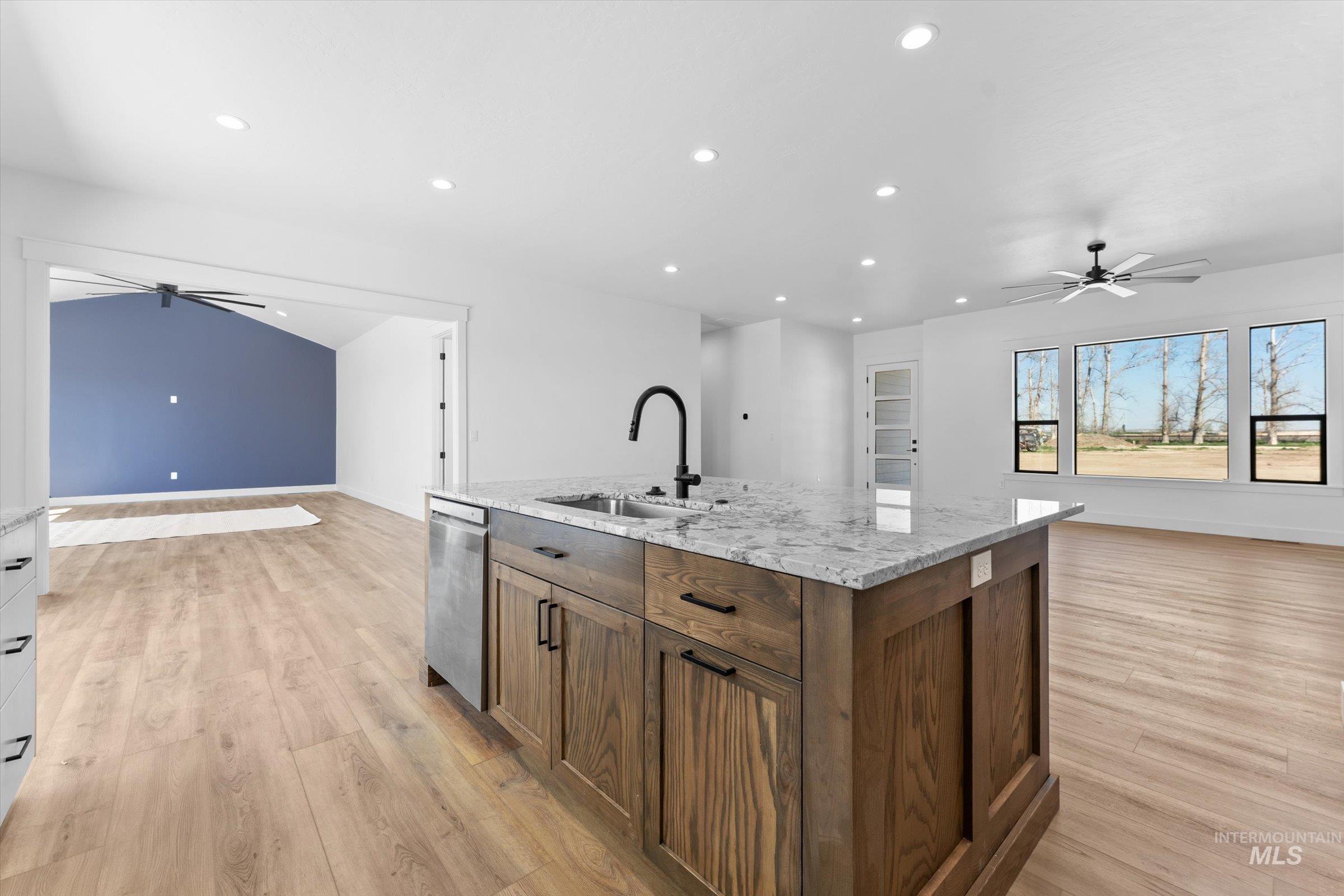 26219 Reed Lane Wilder, ID 83676 - Photo 35 of 35 Kitchen featuring ceiling fan, open floor plan, light stone counters, recessed lighting, and a kitchen island with sink