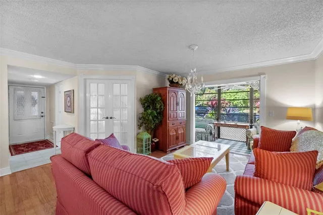 a view of a dining room and livingroom with furniture wooden floor and a chandelier