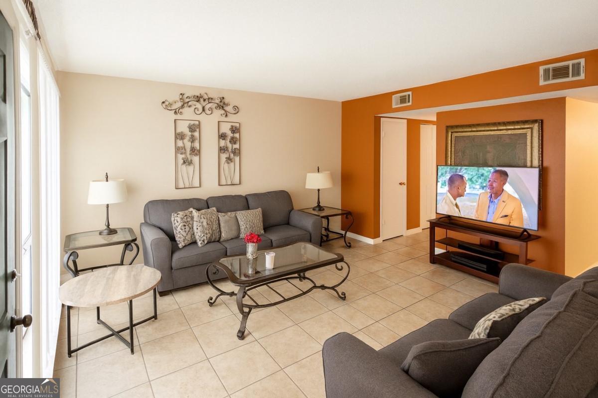 10710 Egmont Road, Unit 19 Savannah, GA 31406 - Photo 2 of 7 a living room with furniture and a flat screen tv