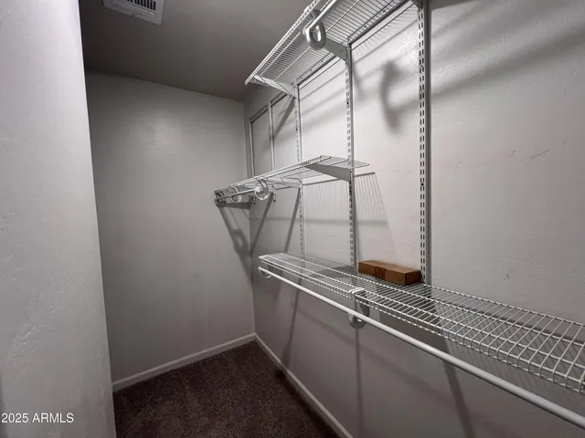 an empty room with closet and a chandelier fan