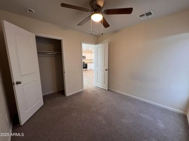 an empty room with a window and a fan