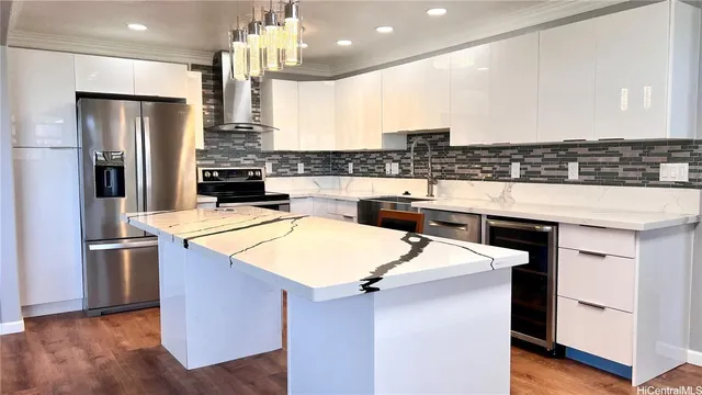 a kitchen with stainless steel appliances kitchen island a refrigerator and a stove top oven