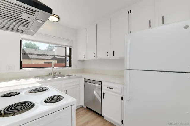 a kitchen with a refrigerator a stove a sink and a cabinets