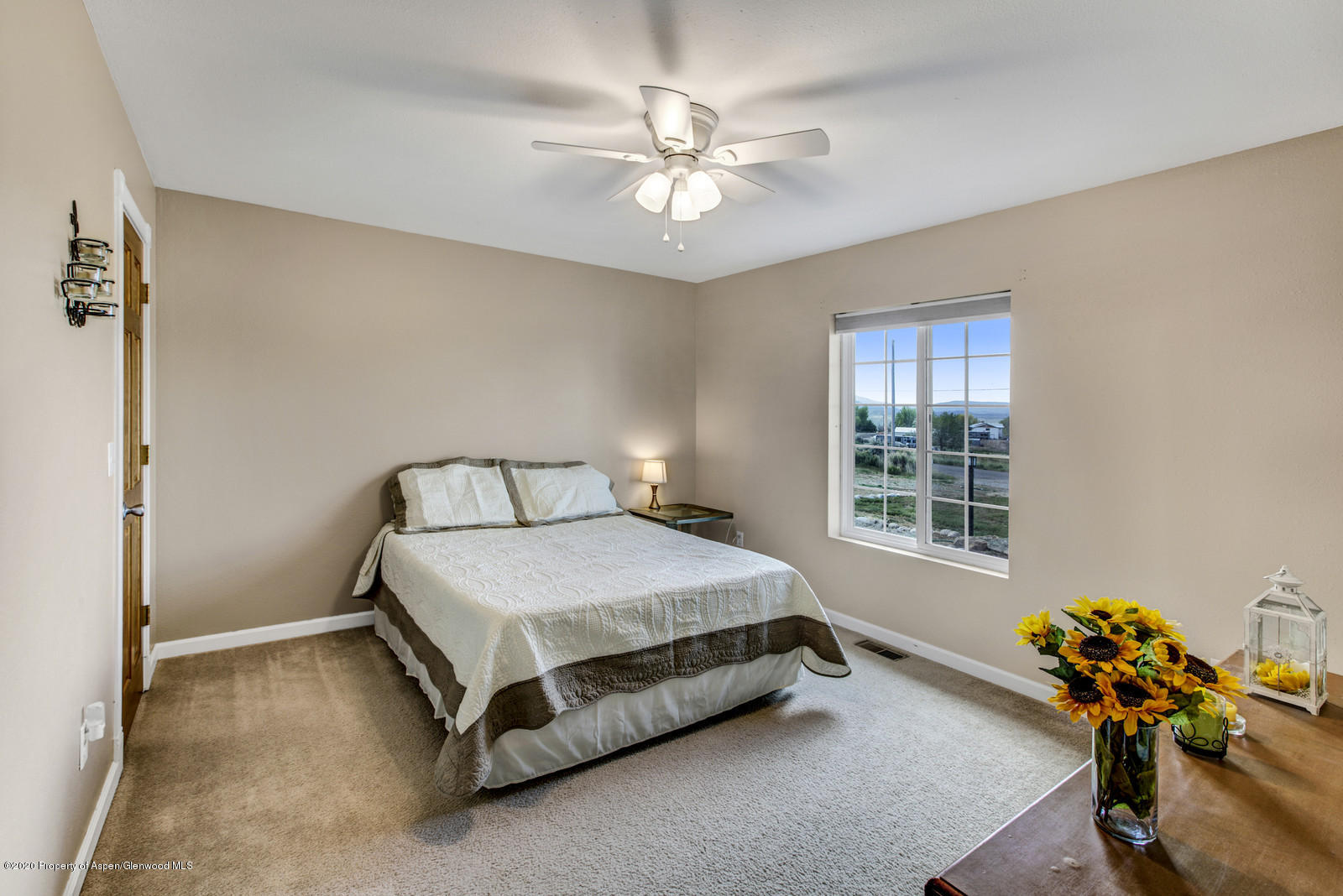 5101 County Road 233 Rifle, CO 81650 - Photo 14 of 26 a bedroom with a bed and a chandelier
