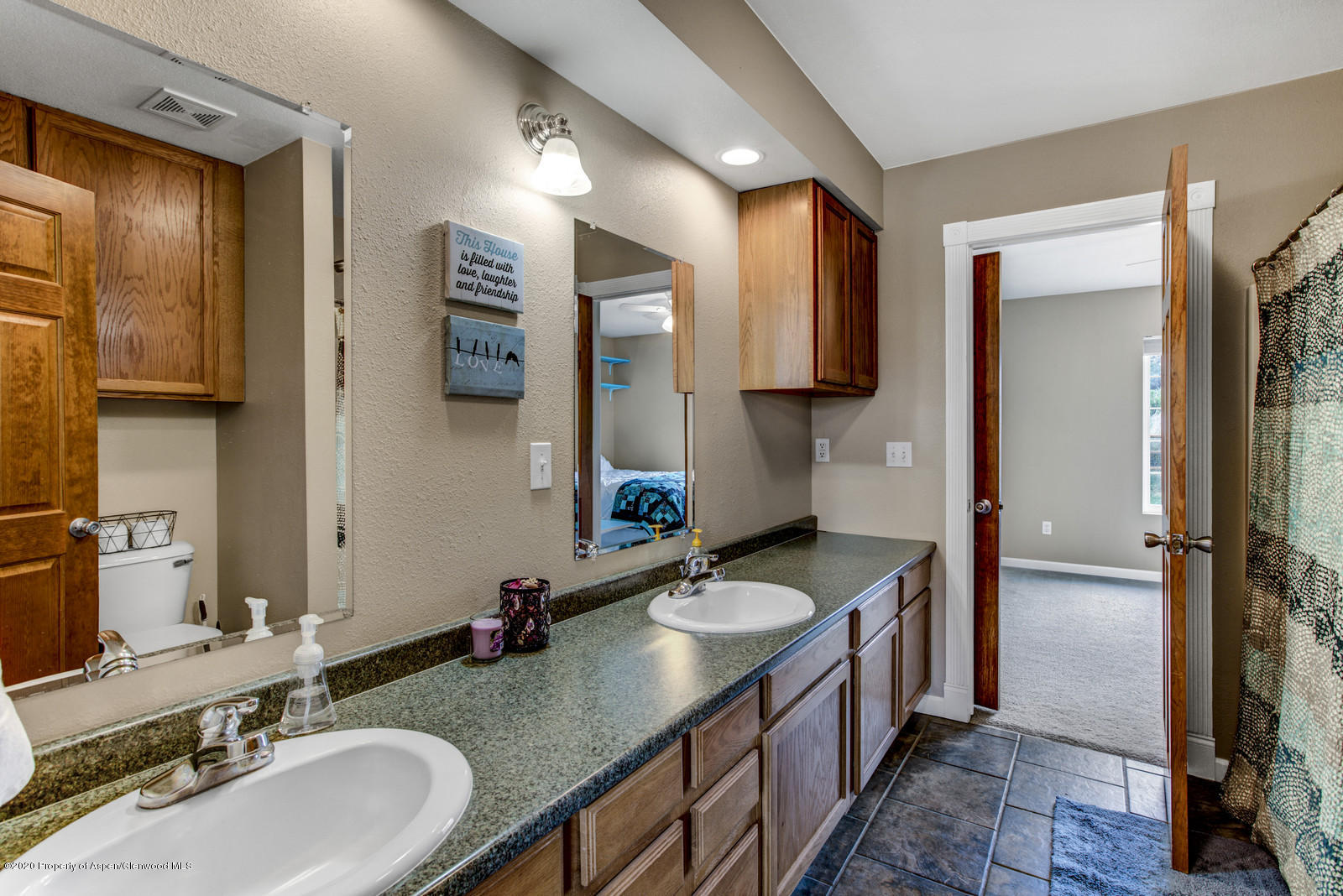 5101 County Road 233 Rifle, CO 81650 - Photo 15 of 26 a bathroom with a granite countertop double vanity sink a mirror and a shower
