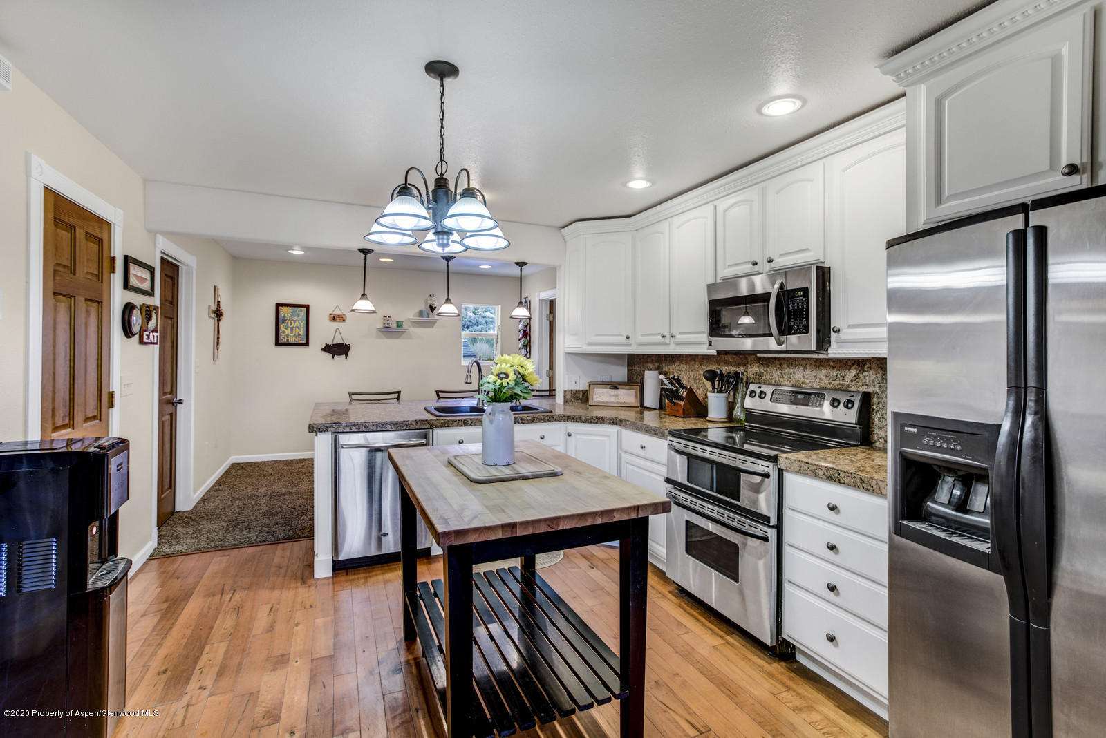 5101 County Road 233 Rifle, CO 81650 - Photo 8 of 26 a kitchen with stainless steel appliances a table chairs refrigerator and cabinets
