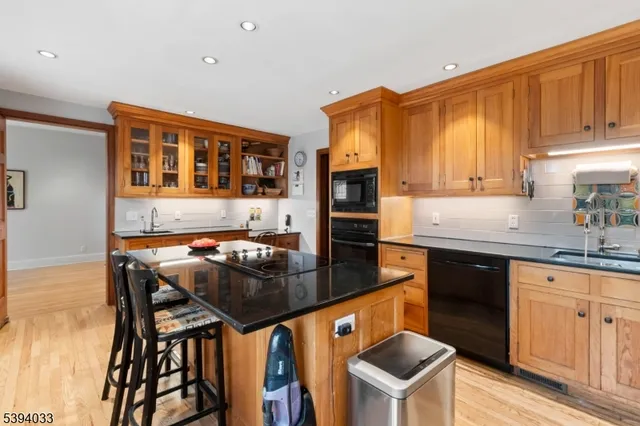 a kitchen with stainless steel appliances granite countertop a stove a sink a microwave a refrigerator and cabinets