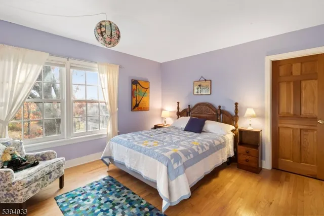 a bedroom with a bed chair and a large window