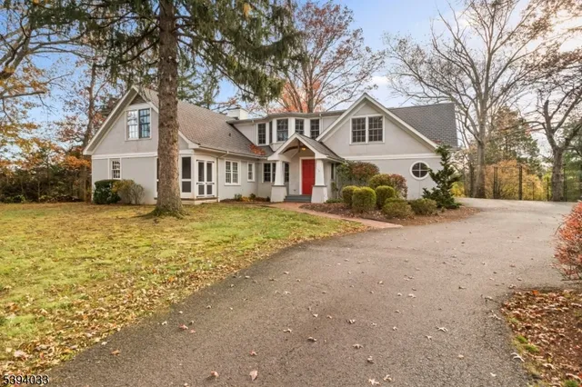 a front view of a house with a yard and large trees