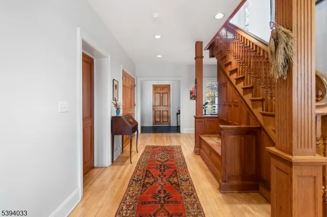 a view of hallway with wooden floor and stairs