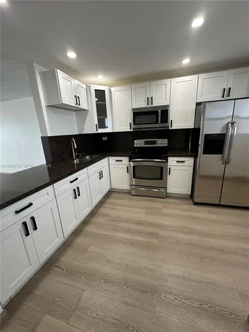 a kitchen with granite countertop a sink and cabinets