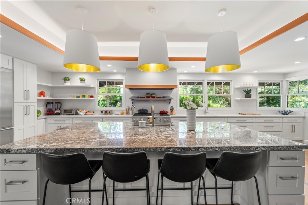 7337 La Soldadera Rancho Santa Fe, CA 92067 - Photo 8 of 60 a kitchen with granite countertop a table chairs stove and cabinets