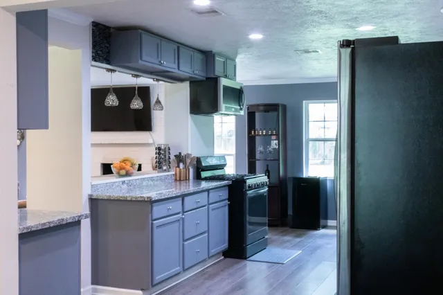 a kitchen with stainless steel appliances granite countertop a refrigerator and a stove top oven