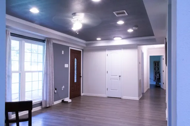 an empty room with wooden floor and windows