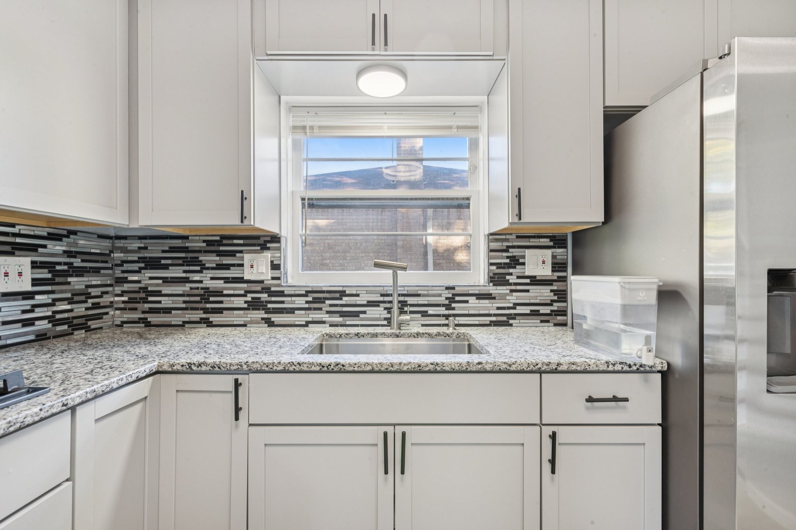 8846 Austin Avenue Morton Grove, IL 60053 - Photo 9 of 35 a kitchen with granite countertop a sink a stove and cabinets