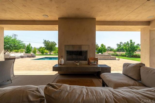 a living room with couches a coffee table and a fireplace with large windows
