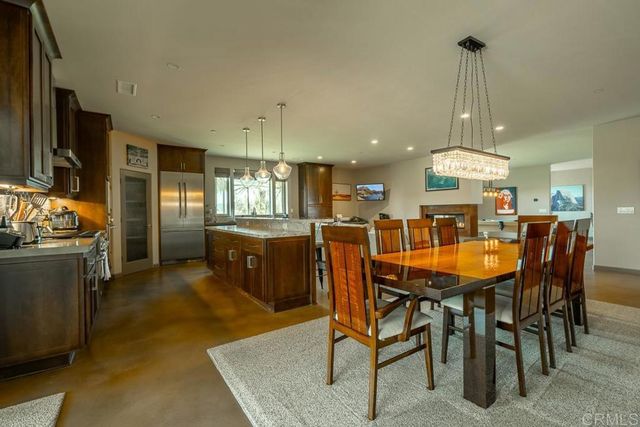 a dining room filled chandelier and kitchen view