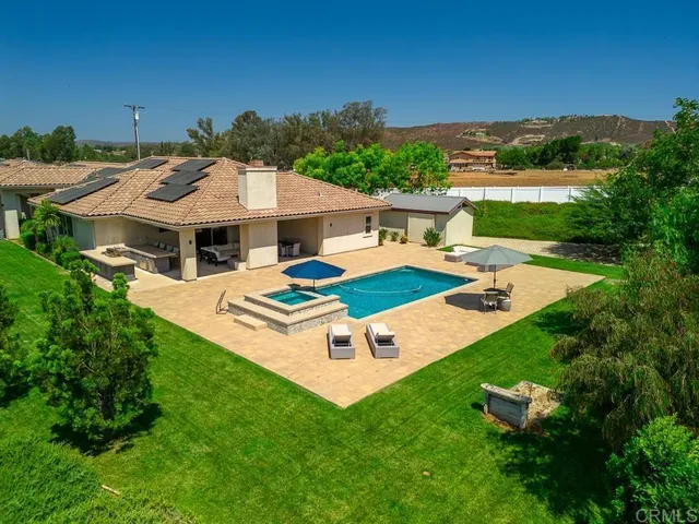 a view of a house with pool and a yard