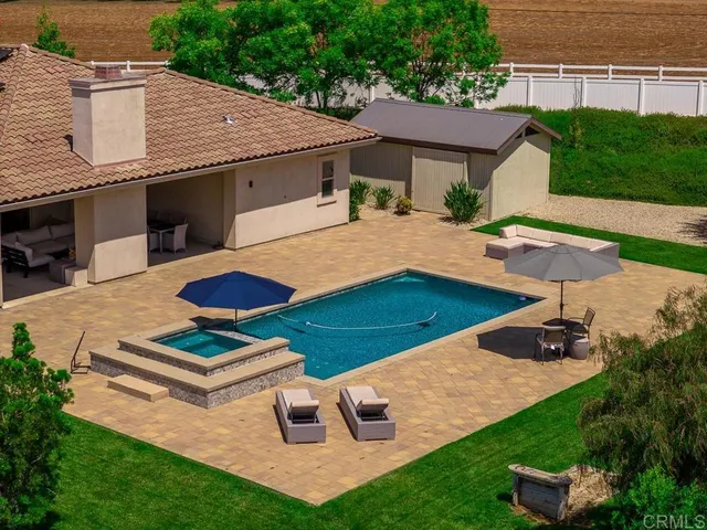 a view of house with backyard swimming pool and outdoor seating