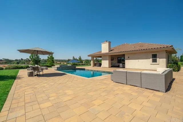 a view of a house with swimming pool and sitting area