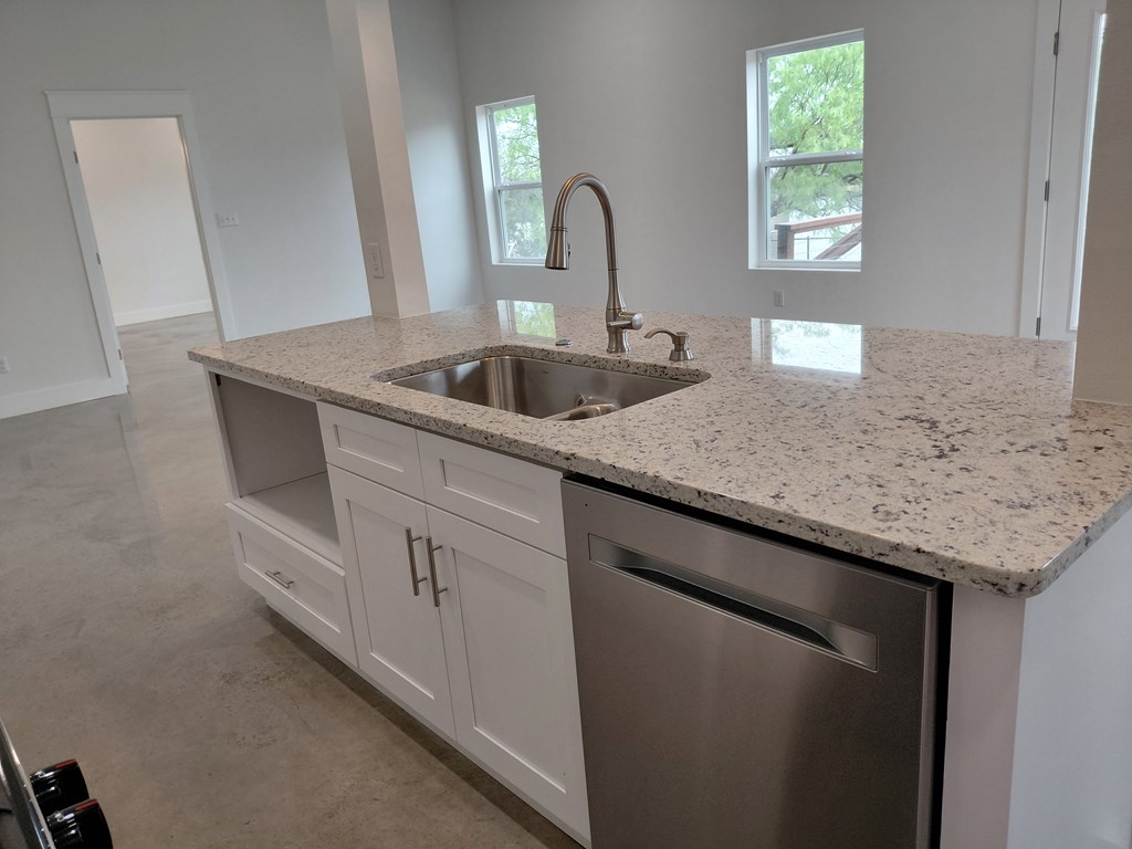 508 West Rainey Street Mason, TX 76856 - Photo 8 of 25 a kitchen with granite countertop white cabinets and a sink