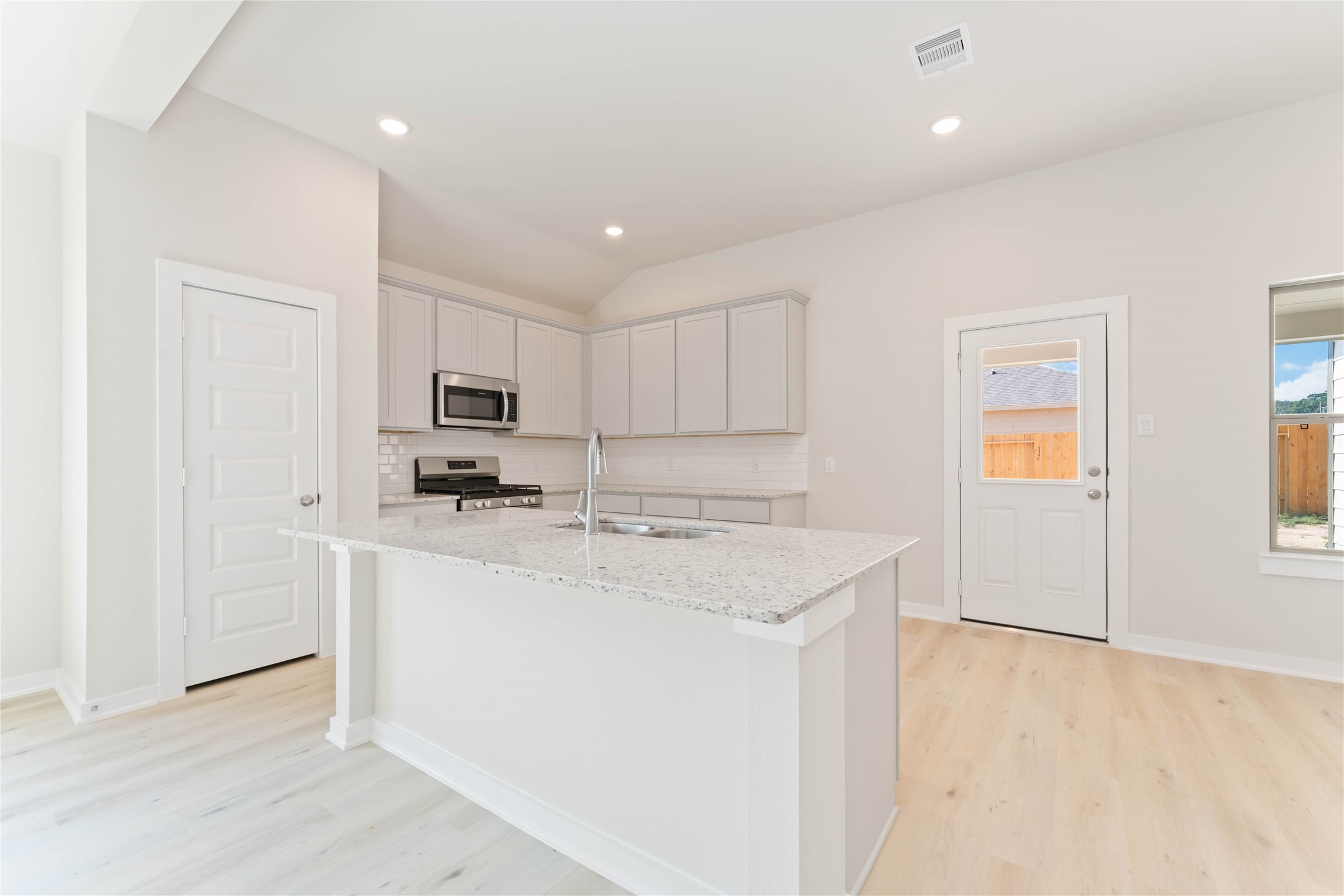 25992 Liberation Road Cleveland, TX 77328 - Photo 8 of 27 a kitchen with stainless steel appliances a sink stove and cabinets