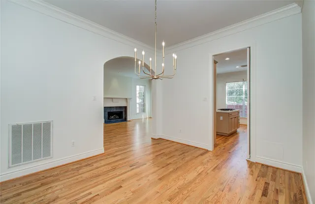 a view of empty room with wooden floor and ceiling fan