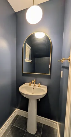 a spacious bathroom with a sink a mirror a bathtub and next to a window