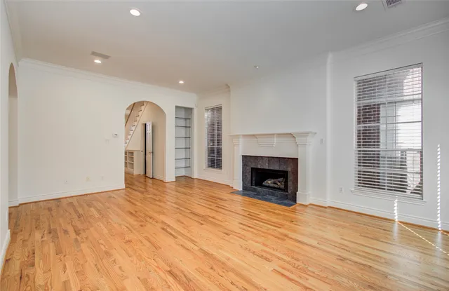 a kitchen with granite countertop white cabinets white appliances a sink and wooden floor