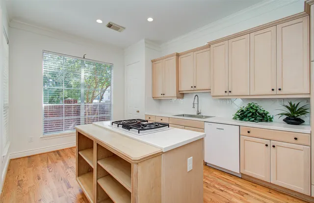 a kitchen with white cabinets and sink