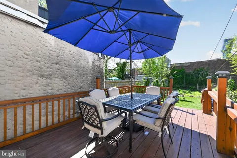 a view of deck with furniture and barbeque oven in the backyard