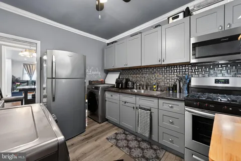 a kitchen with granite countertop a refrigerator stove top oven and sink