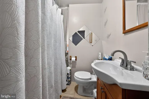 a bathroom with a toilet sink and mirror