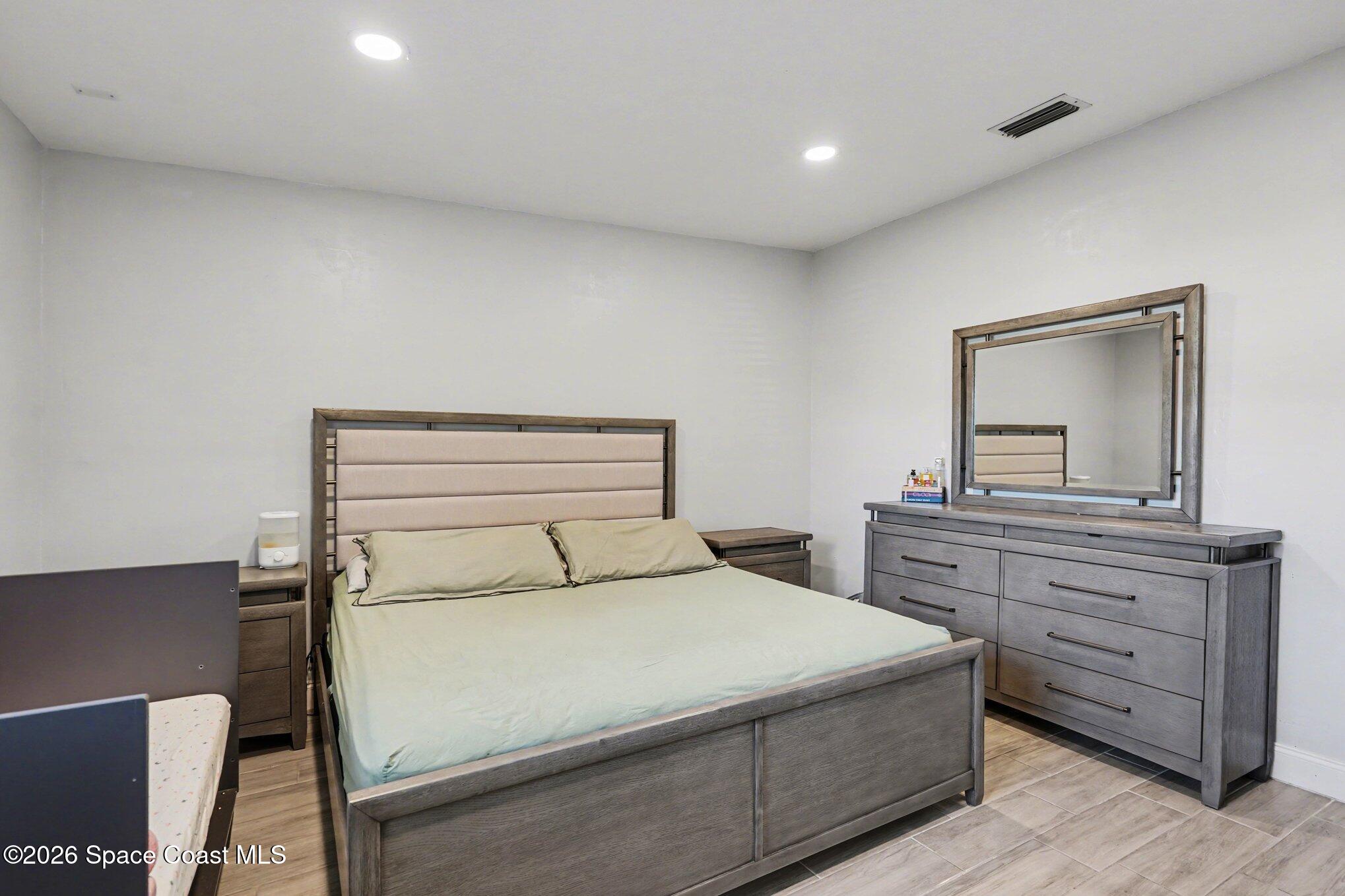 809 Espanola Way Melbourne, FL 32901 - Photo 13 of 27 a bedroom with a bed and a mirror on dresser