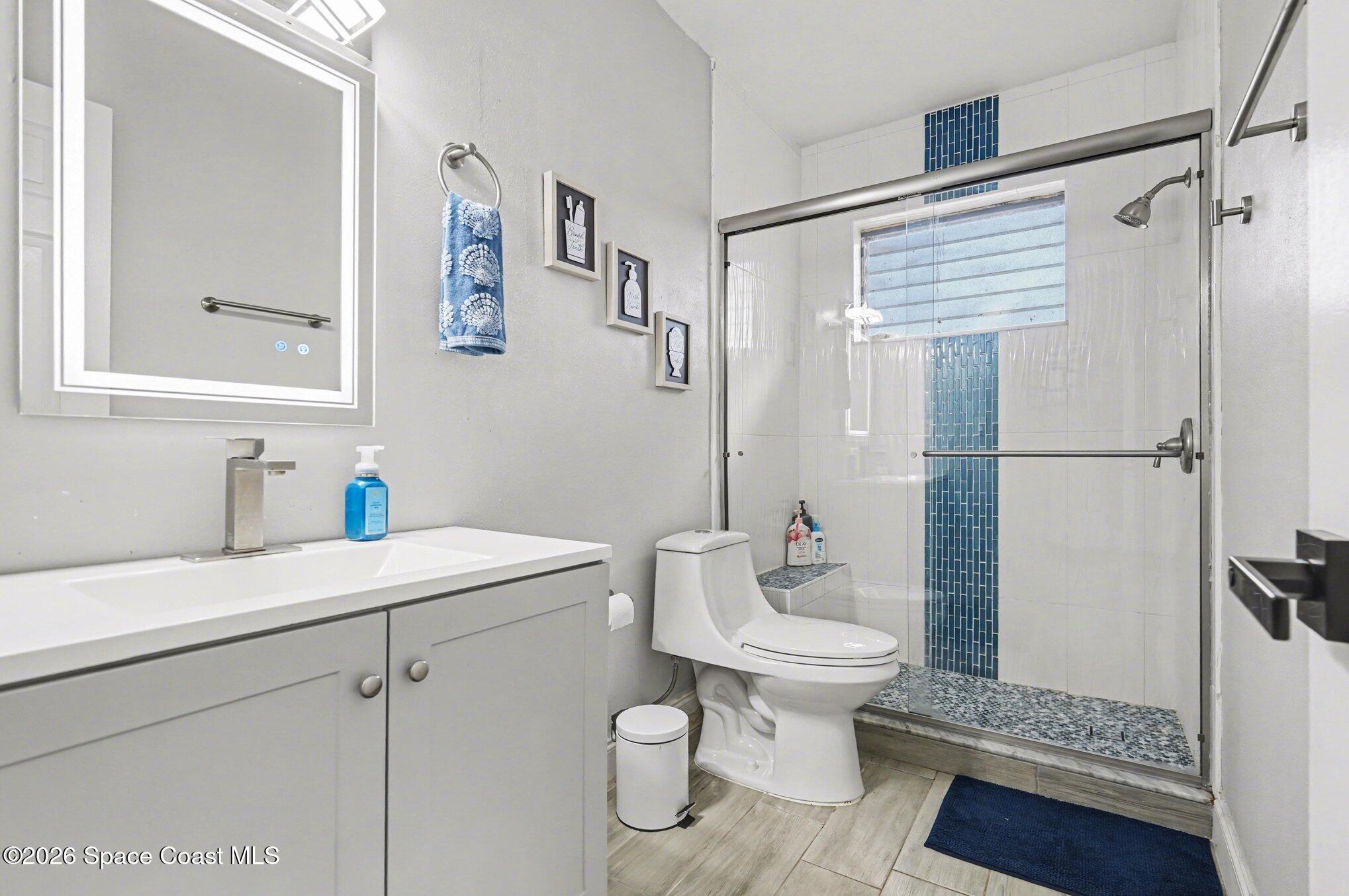 809 Espanola Way Melbourne, FL 32901 - Photo 14 of 27 a bathroom with a sink a toilet and a mirror