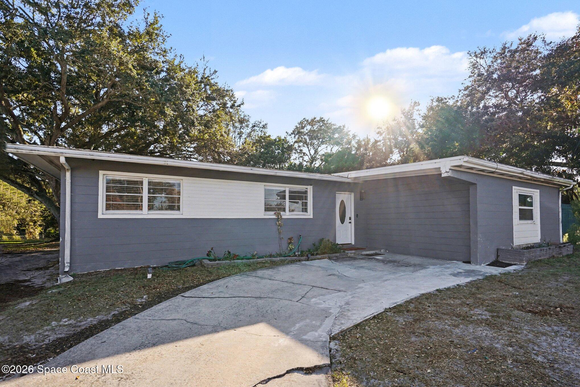 809 Espanola Way Melbourne, FL 32901 - Photo 3 of 27 a front view of a house with a yard and garage