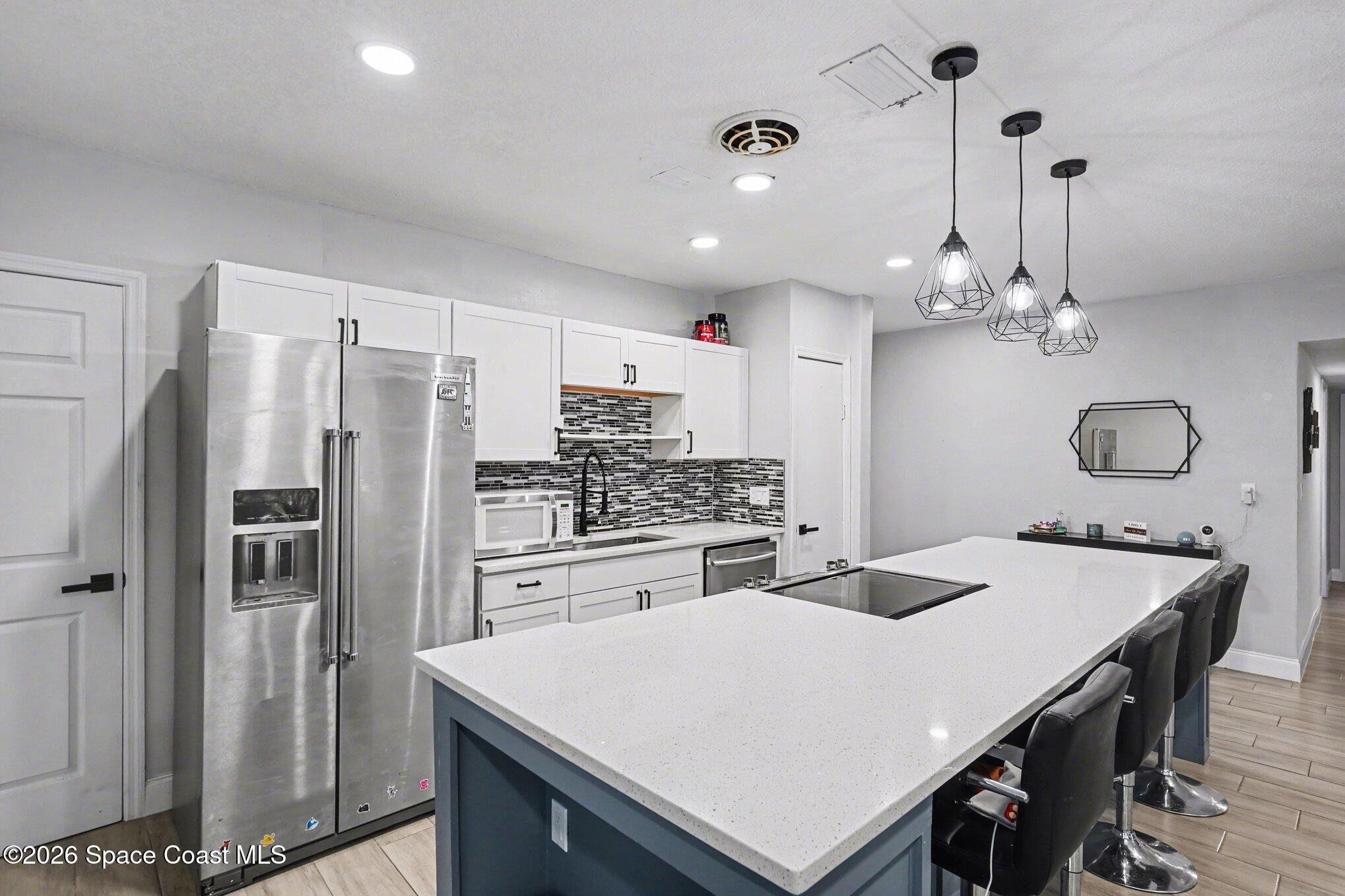 809 Espanola Way Melbourne, FL 32901 - Photo 9 of 27 a kitchen with kitchen island a sink stove and refrigerator