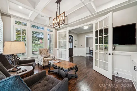a living room with furniture a flat screen tv and a chandelier