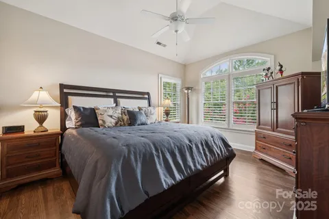 a bedroom with a bed wooden floor and window