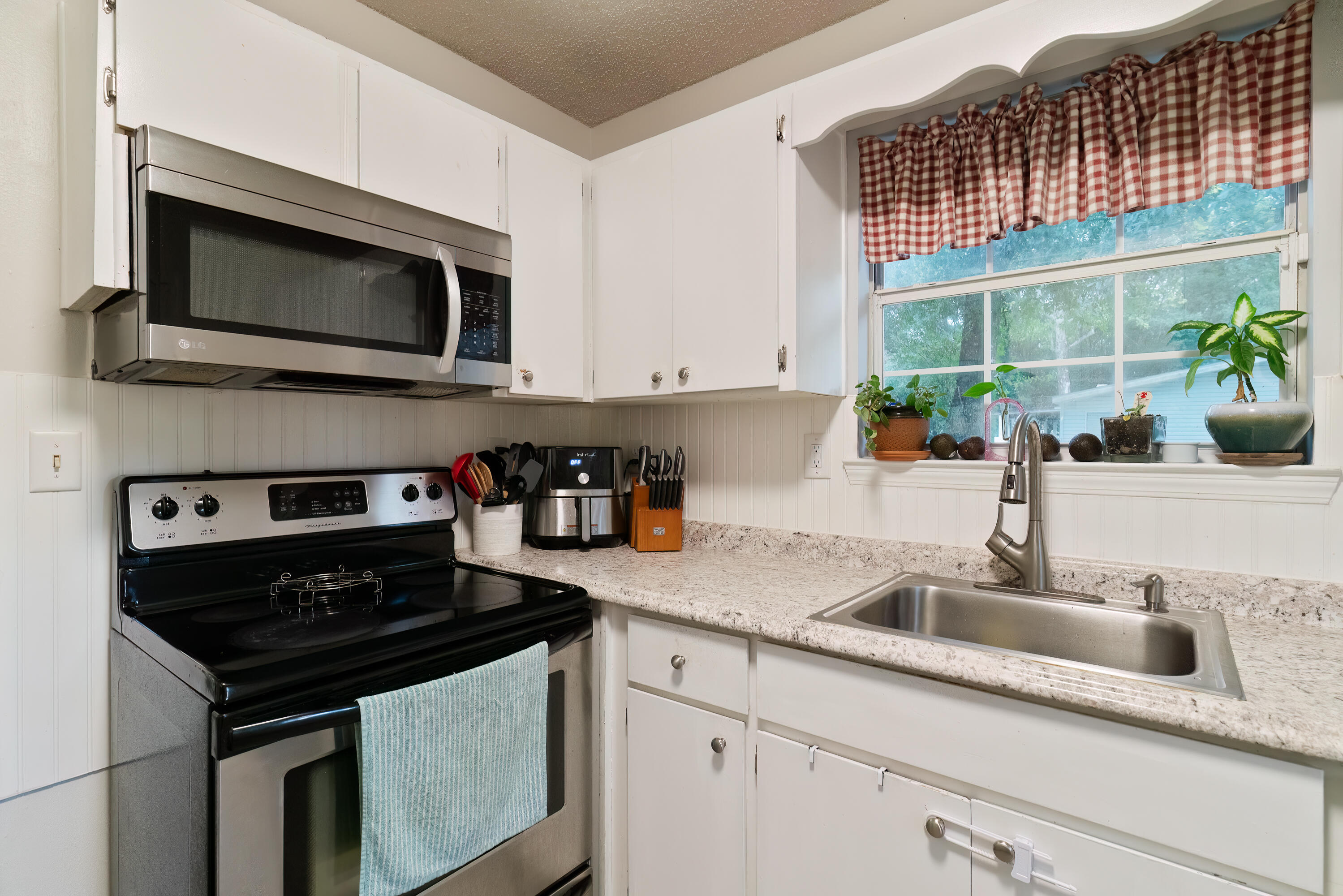 406 Cooper Street Crestview, FL 32539 - Photo 13 of 32 a kitchen with stainless steel appliances granite countertop a sink stove and microwave
