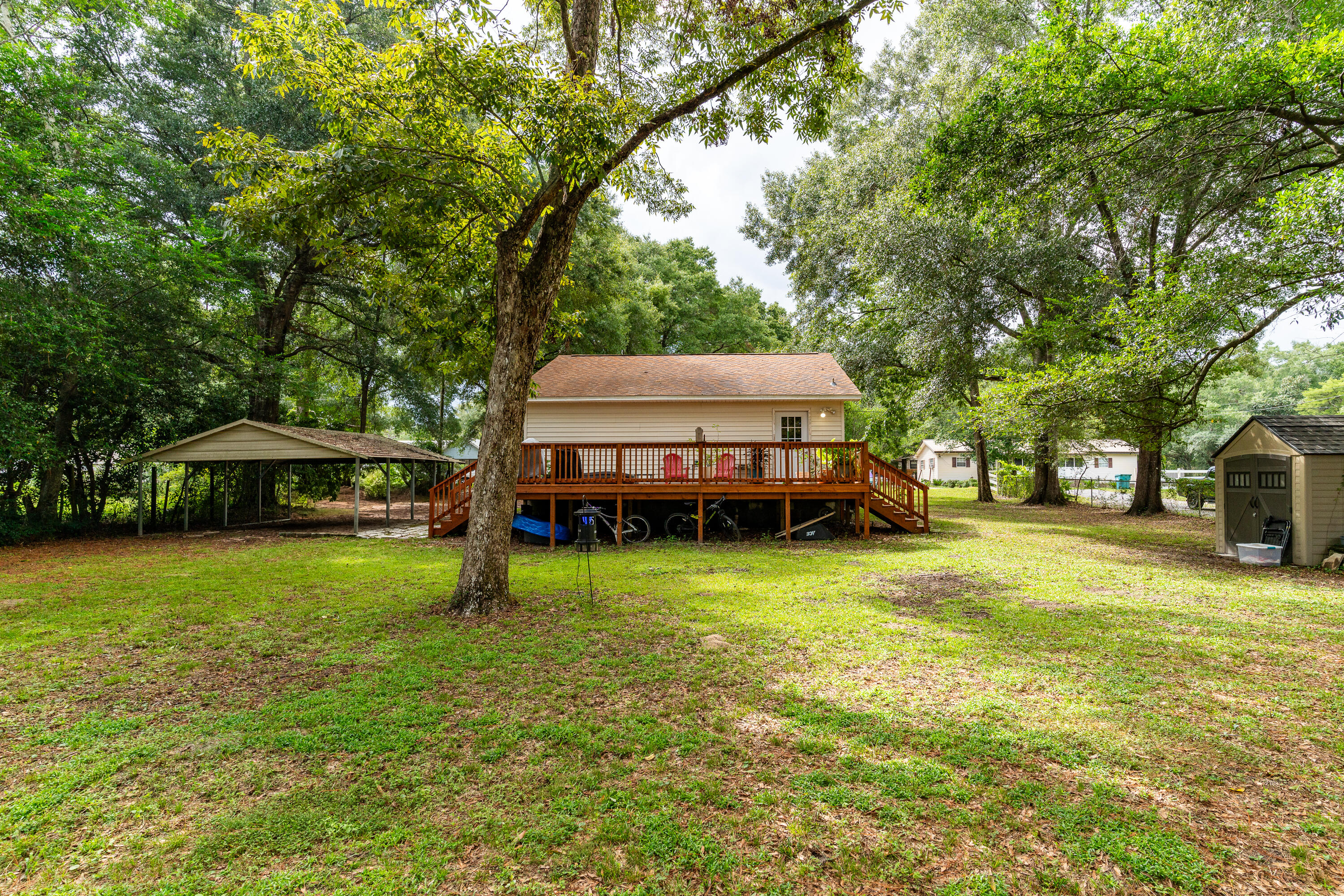 406 Cooper Street Crestview, FL 32539 - Photo 26 of 32 a yellow house sitting in middle of the middle of a yard