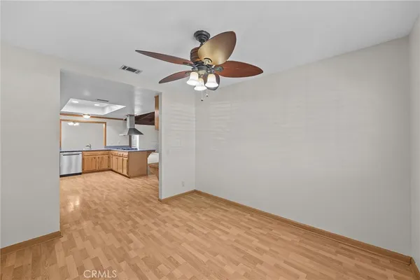 a view of a room with wooden floor and a ceiling fan
