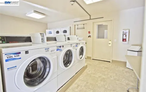a view of washer and dryer with kitchen in the background