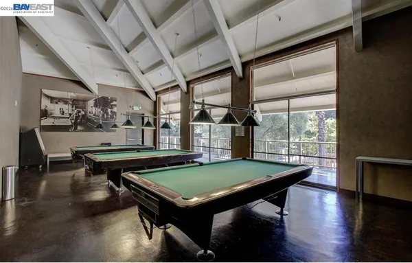 a room with pool table and windows