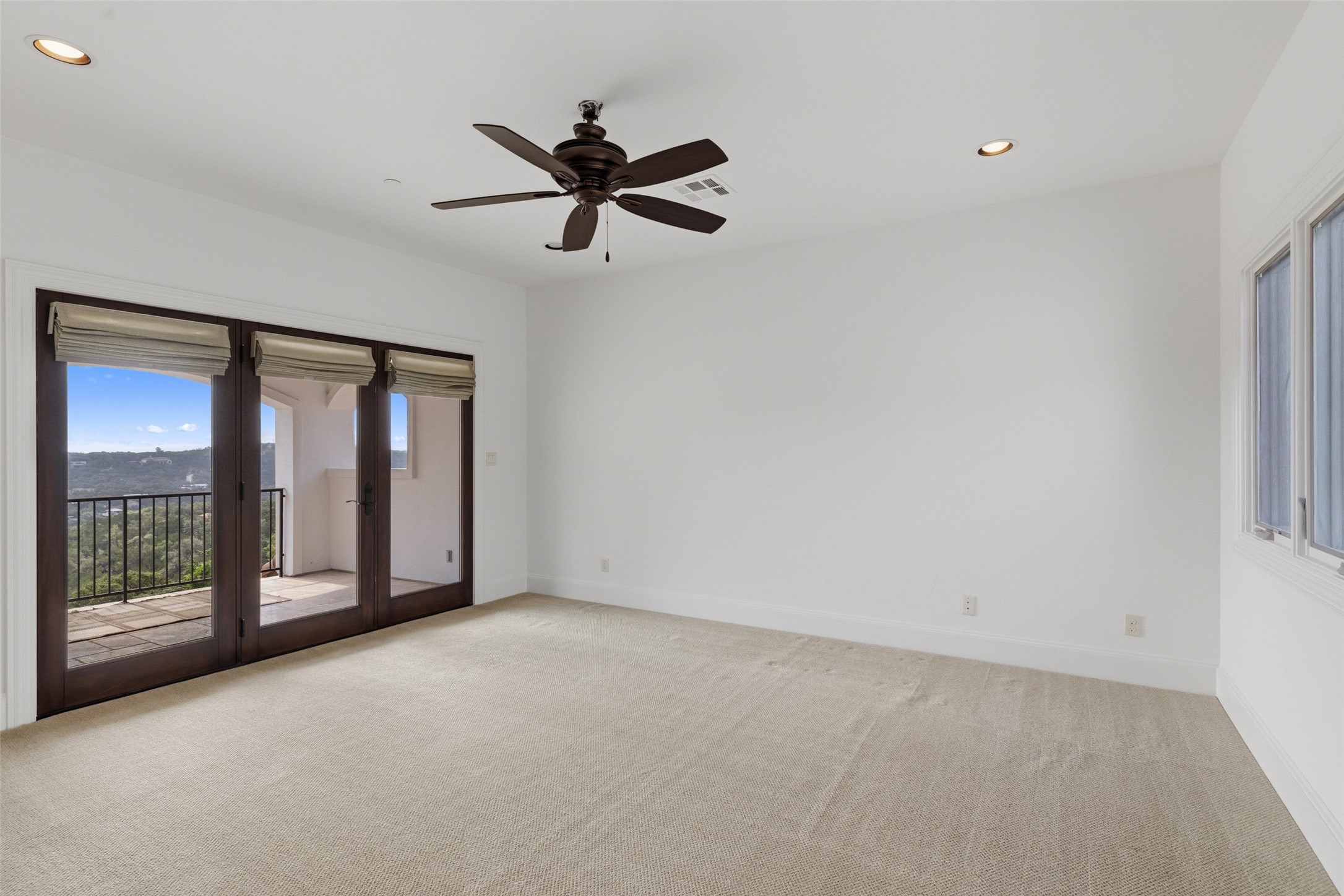 1414 The High Road Austin, TX 78746 - Photo 25 of 40 A spacious bedroom retreat with a private balcony offering inspiring views.