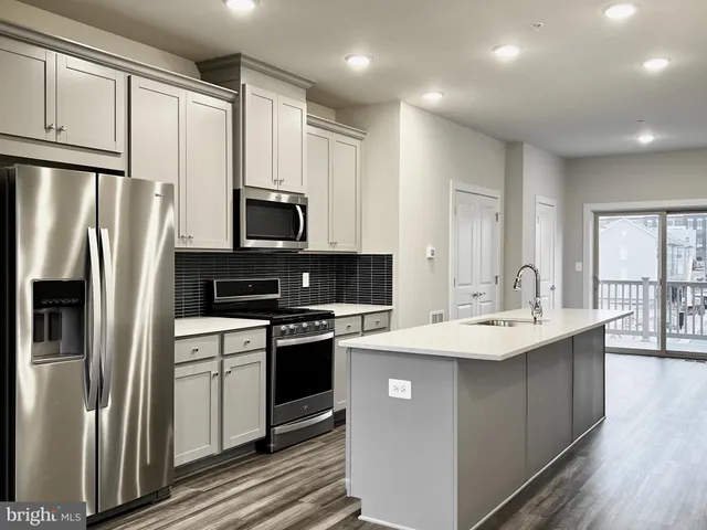 a kitchen with stainless steel appliances a sink stove refrigerator and cabinets