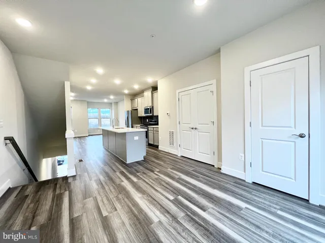 a open kitchen with white cabinets and stainless steel appliances